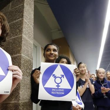 Students hold stickers about to be placed on a new all-gender bathroom as members of the cheer squad applaud at Nathan Hale High School in Seattle, WA on May 17, 2016. 