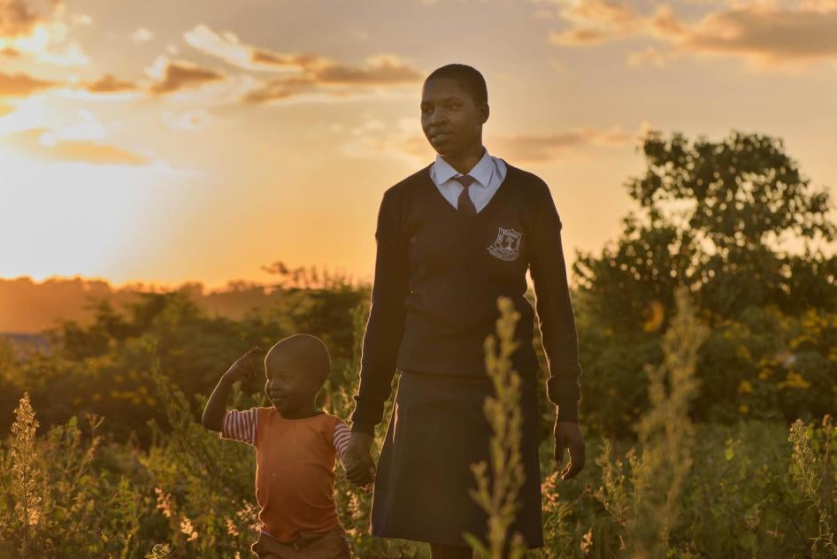 “Angela,” 20, walks with her son near her home after returning from school in Migori county, western Kenya