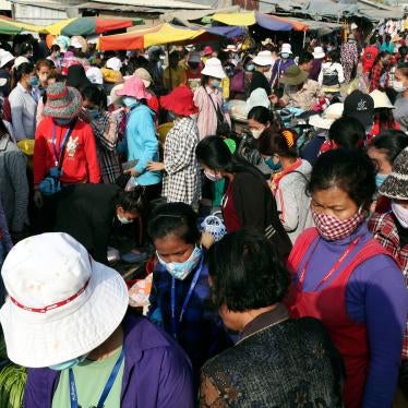 Garment factory workers wear face masks as they walk out at the end of their work shift March 20, 2020, near Phnom Penh, Cambodia.