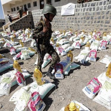 A uniformed soldier walks through aid packages