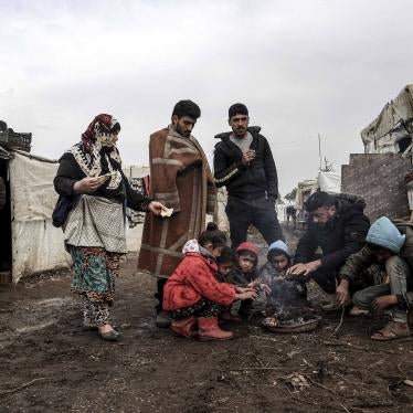 A group gathers around a small fire