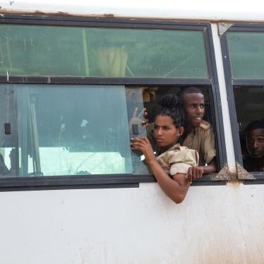 Soldiers lean out of a bus window