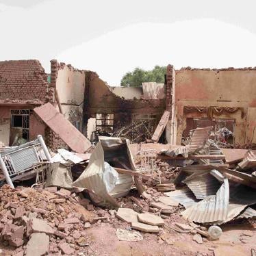 Man stands next to building destroyed during fighting in Khartoum, Sudan