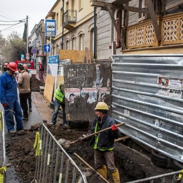 Workers dig up the side of a road in Tbilisi, Georgia, March 23, 2018. 