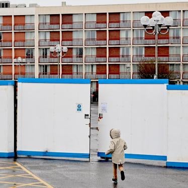 A child plays outside the gates of a hotel