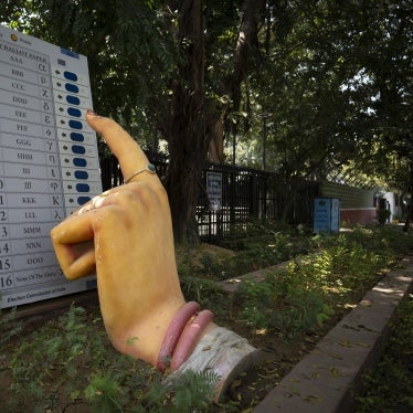 A model of a woman's finger pressing the button of an electronic voting machine