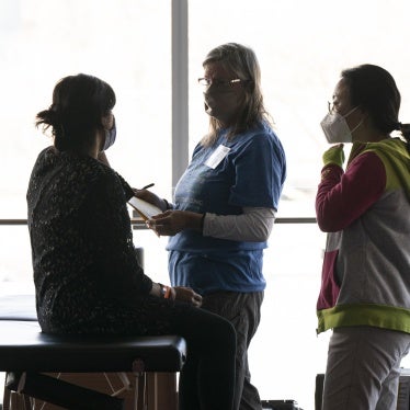 Volunteers offer free physical therapy services for a patient at the Seattle/King County Clinic, during an annual free healthcare event held at Seattle Center on February 16, 2024.