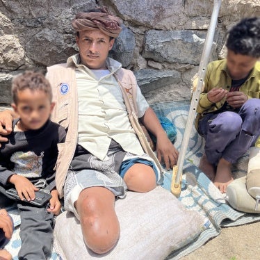 Abdullah, 35, who lost both of his legs to a landmine while taking goats to graze, with his two children, Al-Shaqb, Yemen, April 27, 2024. 