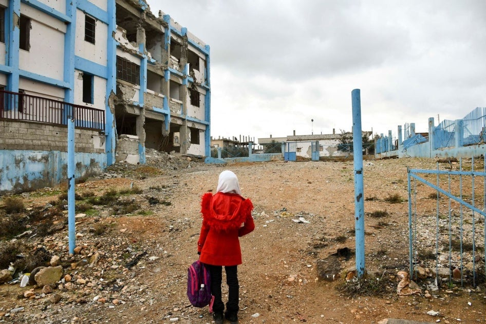 A 14-year-old girl looks at her old school, which was damaged by conflict, in Dara’a Albalad, Syria, on February 7, 2022. © UNICEF/UN0635253/Shahan