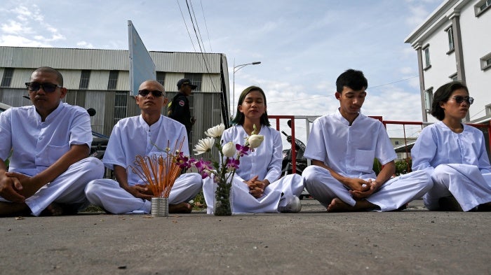 Cambodian environmental activists from the group Mother Nature sit near barricades blocking a street to the municipal court in Phnom Penh, Cambodia, June 5, 2024.