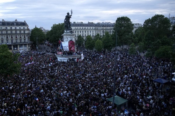 People stand in Republique Plaza as they react to the projection of results during the second round of the legislative elections, in Paris, France. July 7, 2024.
